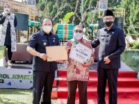 Caption: Bupati Hendy Siswanto menyerahkan penghargaan kepada Misnawar.