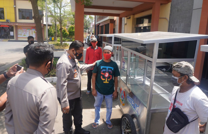 Foto: Kapolres Bojonegoro, AKBP EG Pandia, saat memberikan modal usaha berupa gerobak untuk berwirausaha.