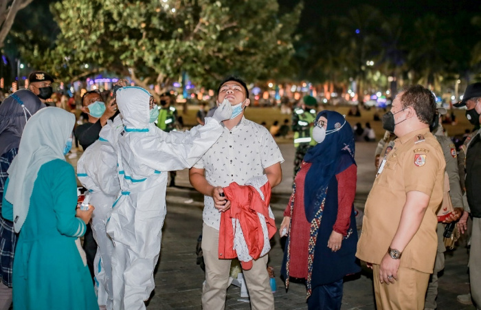 Foto: Salah satu warga menjalani tes swab di alun-alun Jember, saat Bupati melakukan inspeksi pada malam hari di tempat keramaian umum.