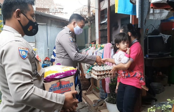 Foto: Personil Sat Binmas Polres Sampang, saat melaksanakan kegiatan Jum’at Sedekah, mengunjungi rumah Emilia (3), di jalan Garuda Kelurahan Gunung Sekar Sampang – Madura.