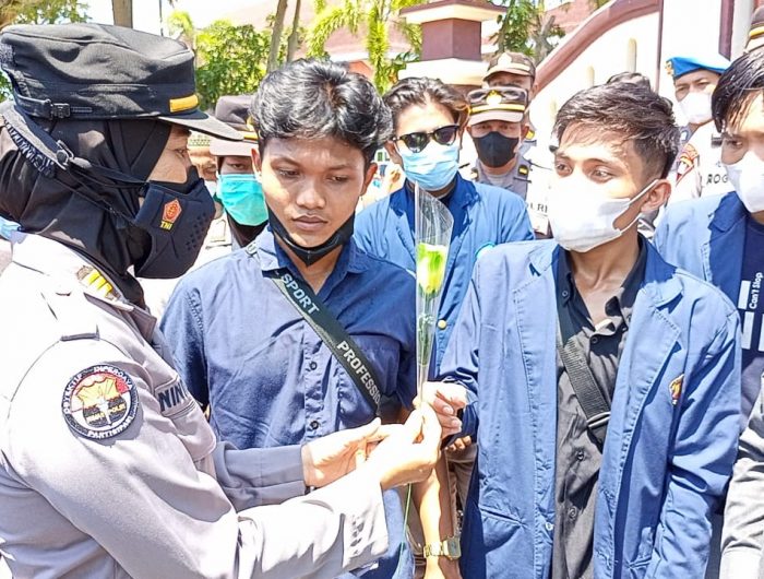 Foto: Polwan Polres Pamekasan melakukan aksi simpatik bagi-bagi bunga kepada peserta unjuk rasa dari kalangan mahasiswa.