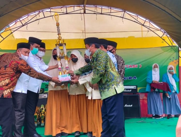 Foto: Bupati Pamekasan H. Baddrut Tamam didampingi Kepala MAN 1dan Kadisdikbud, Kepala Kemenag yang mewakili menyerahkan tropi juara Ajang Kompetisi Siswa Berprestasi (AKSI 2022) Tingkat SMP MTs Se-Madura.