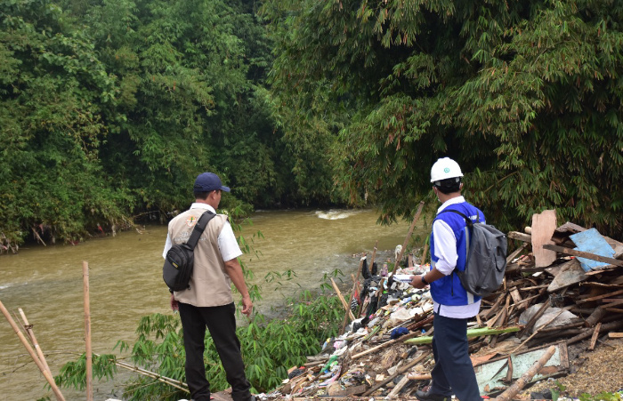 Foto: Petugas Perumda Air Tirta Kahuripan bersama tim DLH saat melihat tumpukan sampah di bantaran sungai Ciliwung.