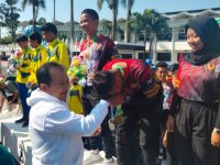 Foto: Bupati Jember Hendy Siswanto mengalungkan bunga ke tim Drum Band Jember yang meraih 5 medali emas.
