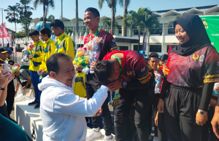 Foto: Bupati Jember Hendy Siswanto mengalungkan bunga ke tim Drum Band Jember yang meraih 5 medali emas.
